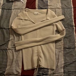 A cream long sleeve crop top with drawstrings